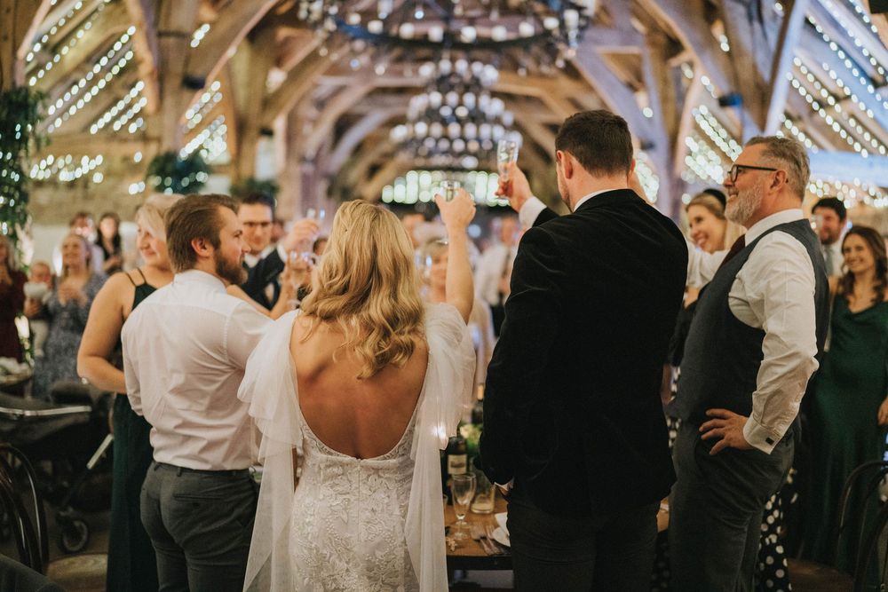 Dancing couples fill the dance floor at an elegant wedding reception under twinkling string lights.