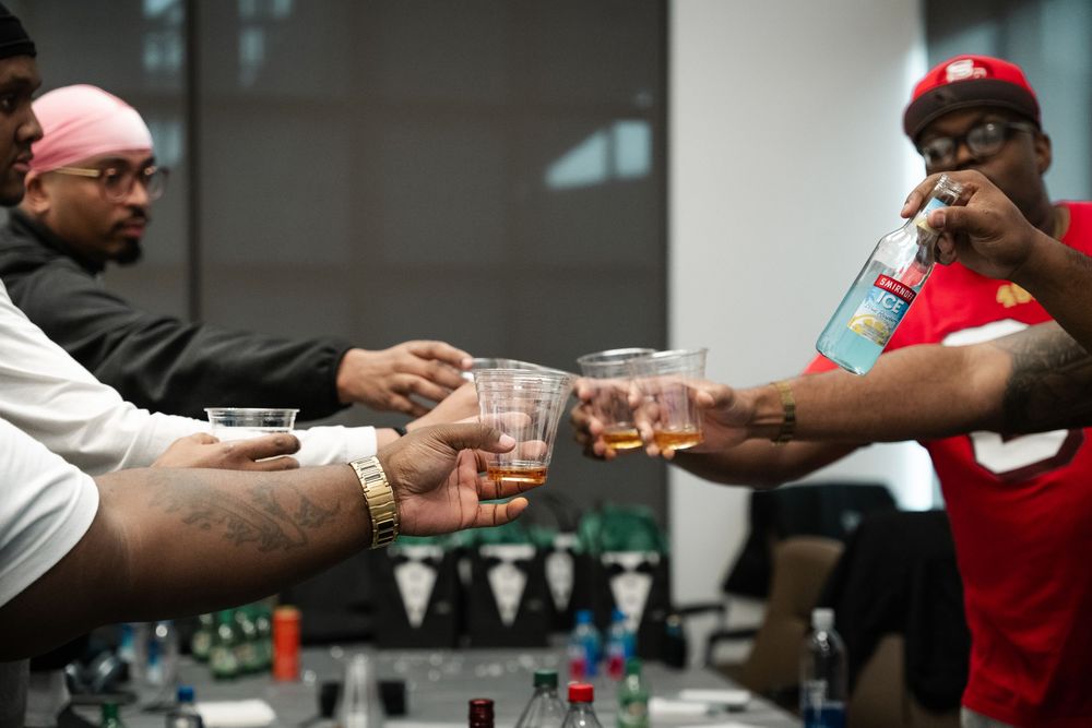 People toasting with glasses at a bar counter during a celebration.