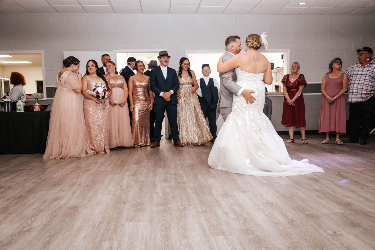 Wedding reception dance floor scene with bridesmaids in pink dresses watching the couple.