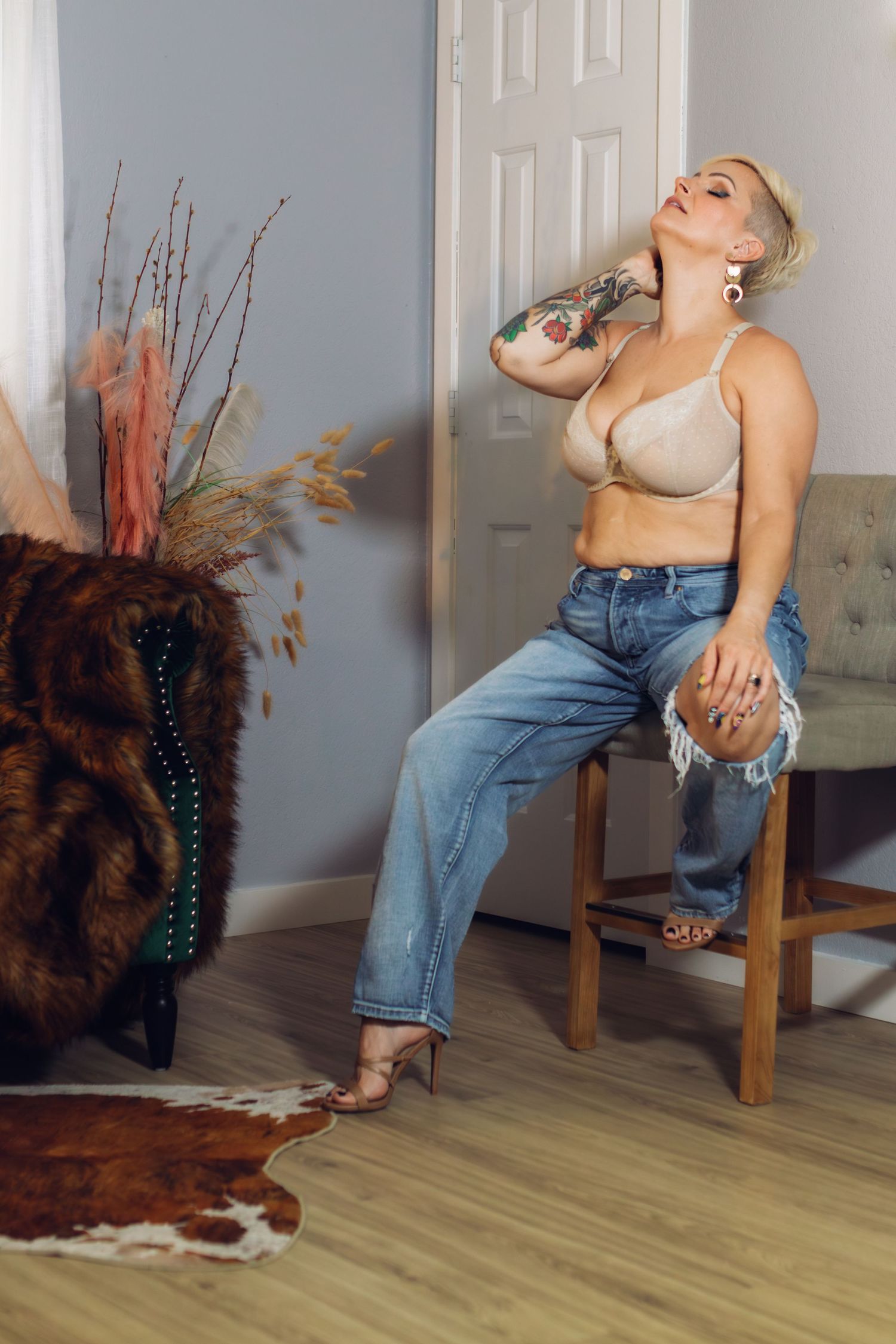 A woman sits on the edge of a chair in a light photography studio in Fort Worth, TX.