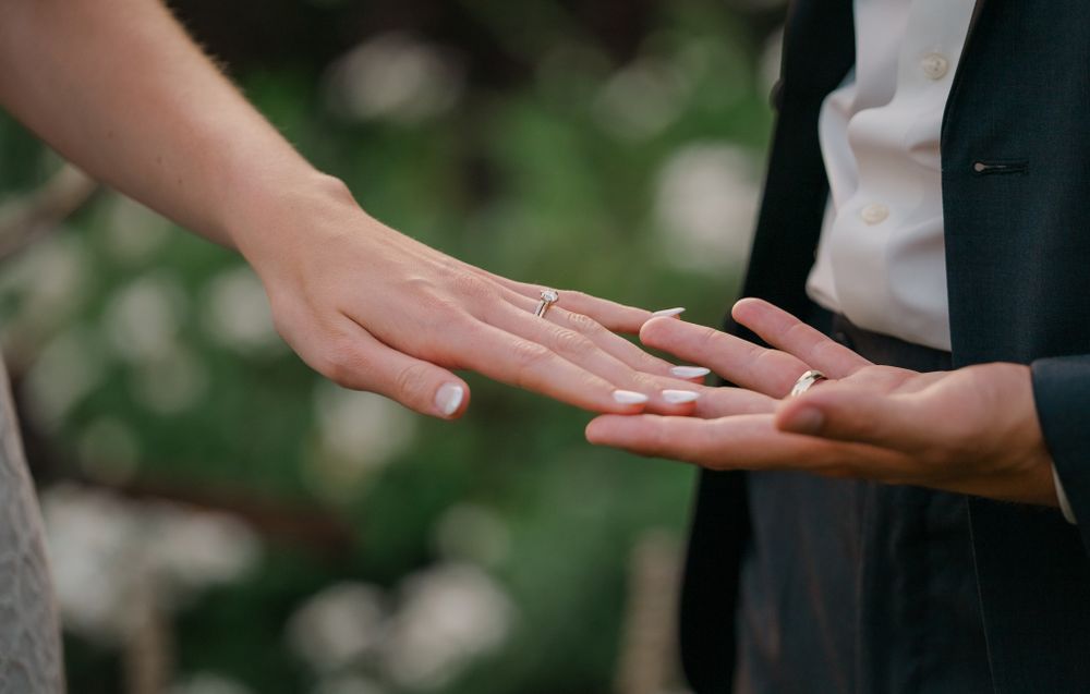 groom admiring brides rings with holding her hand