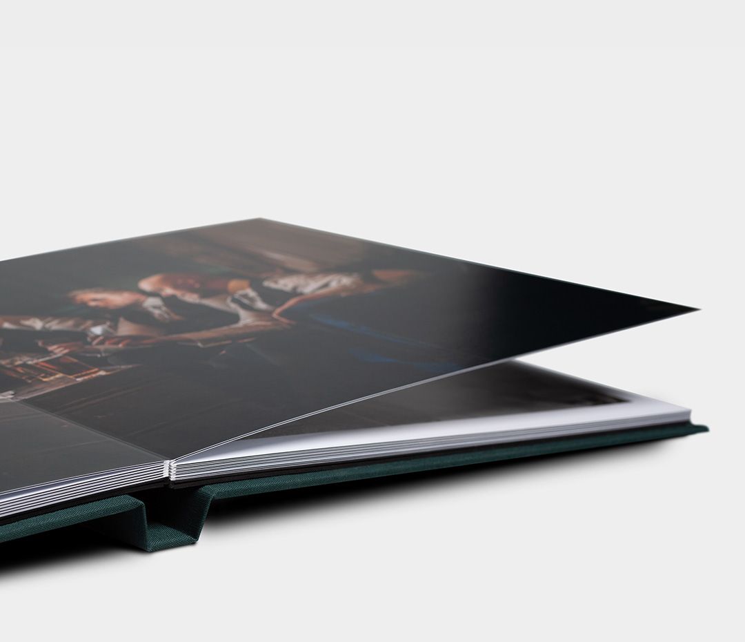 Close-up view of a modern black wedding album's layered pages.