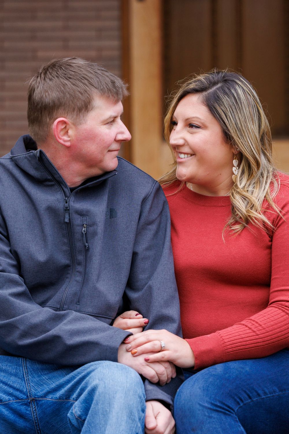 A couple in casual wear shares an intimate moment while sitting together.