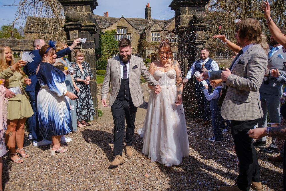 Bride and groom in the confetti line at Holdsworth House