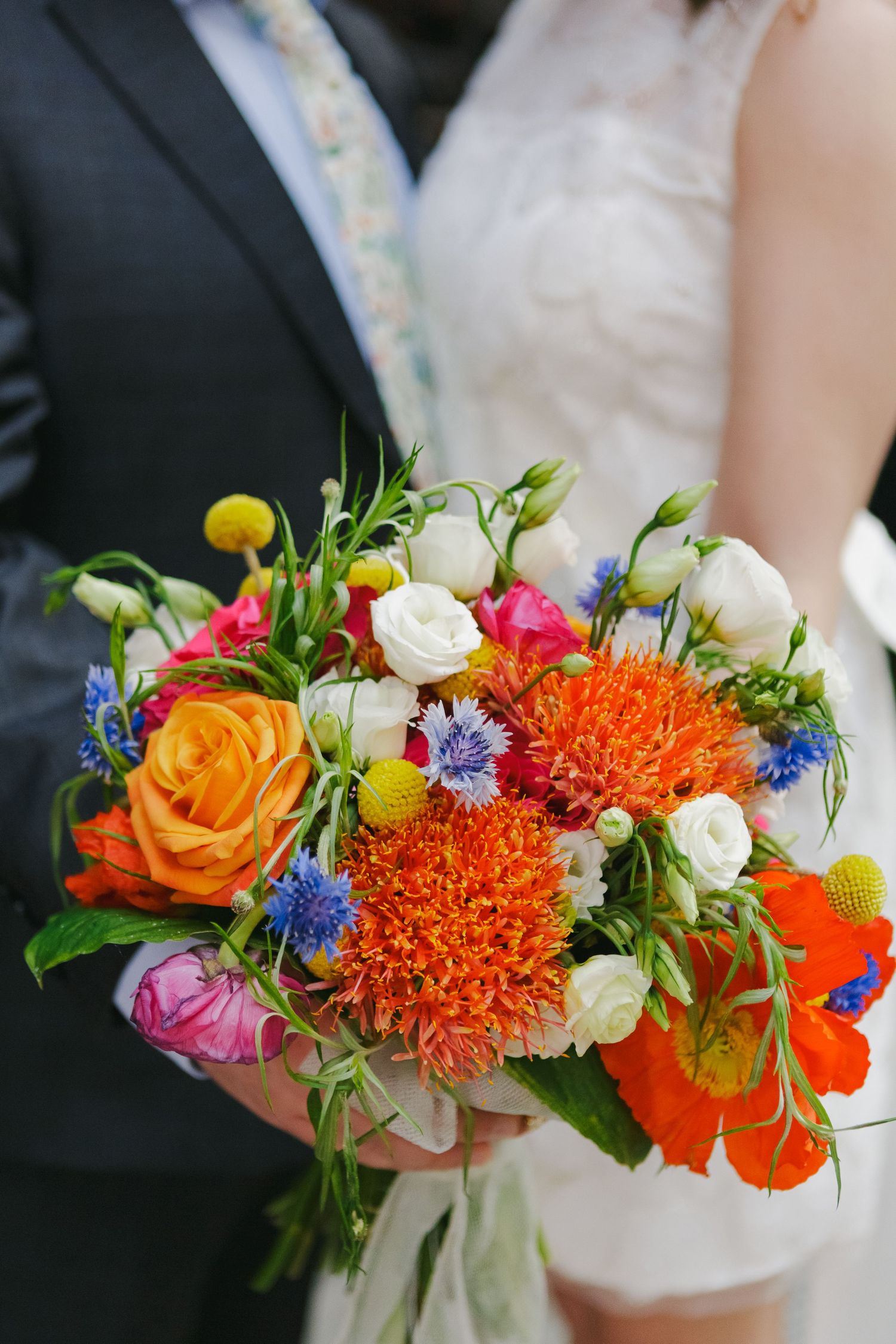 Close-up of couple holding their bouquet, showcasing delicate florals and the love shared on their special day.