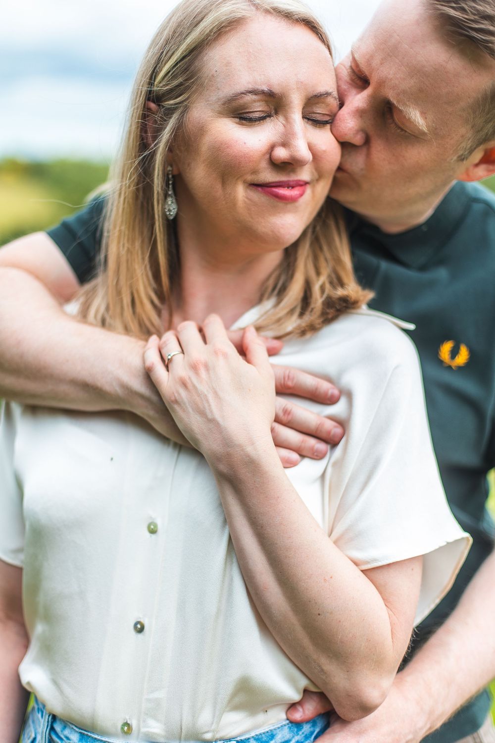 An intimate moment between a couple as they share a tender embrace outdoors with soft natural lighting.