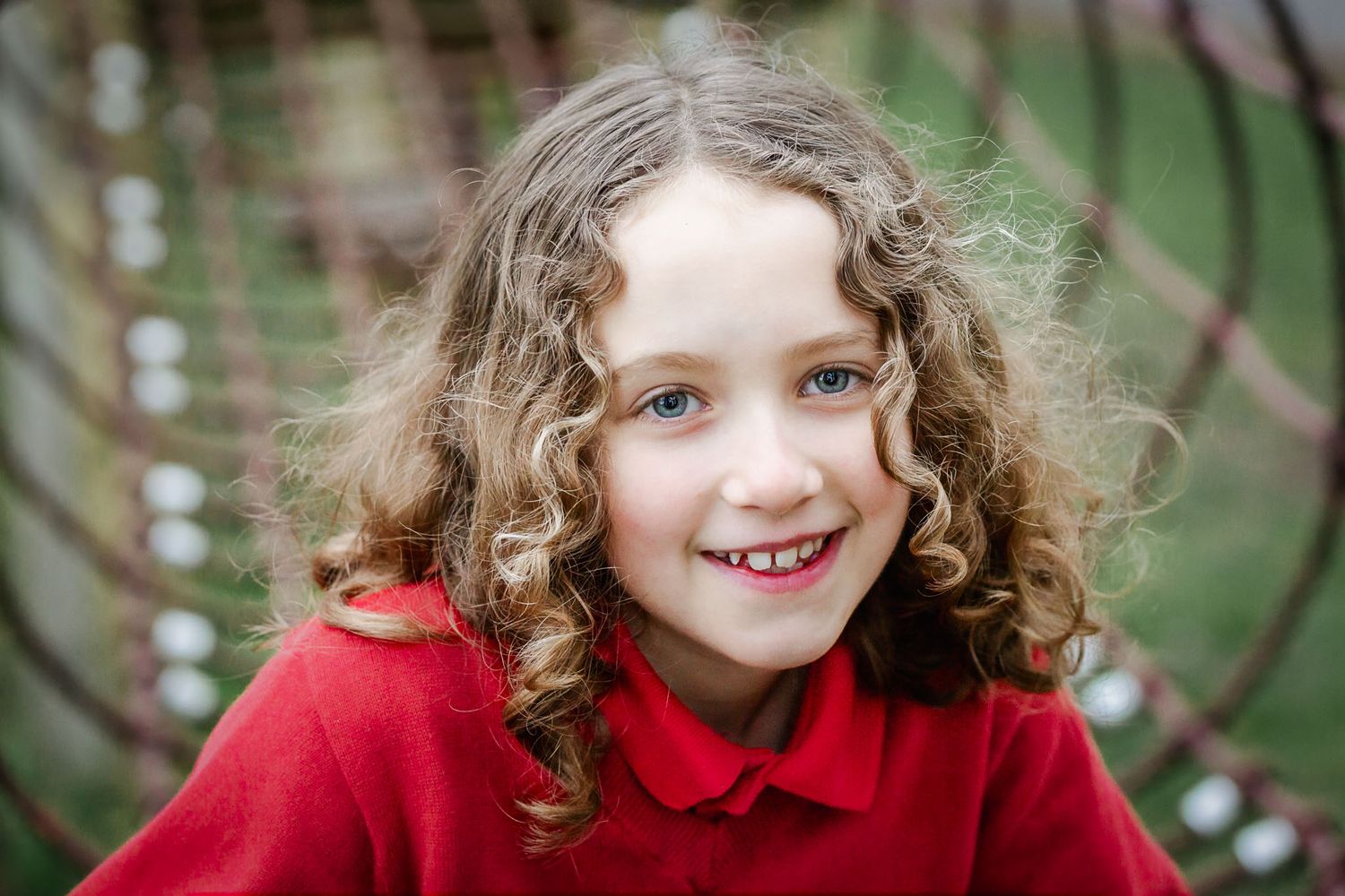 A school girl looks relaxed as she smiles to camera during a school photos mini session in the playground. Bristol school photographer
