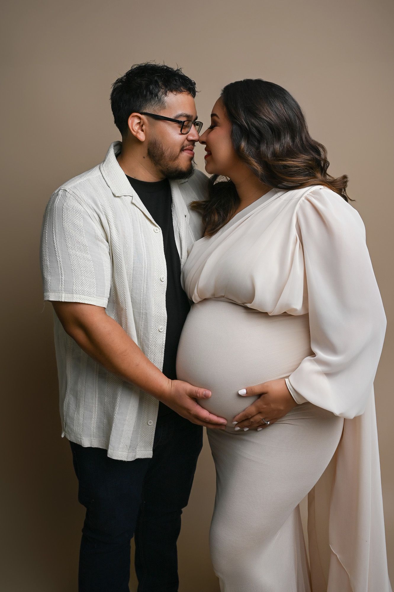 Couple shares a quiet, loving moment in-studio during their fine art Fresno maternity photography session.