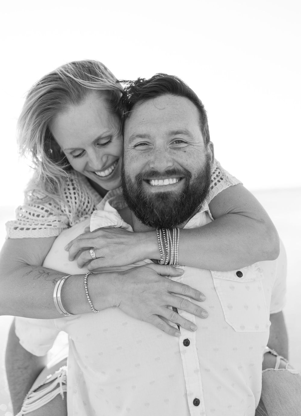 Couple hugging tightly, smiling at the camera with joy