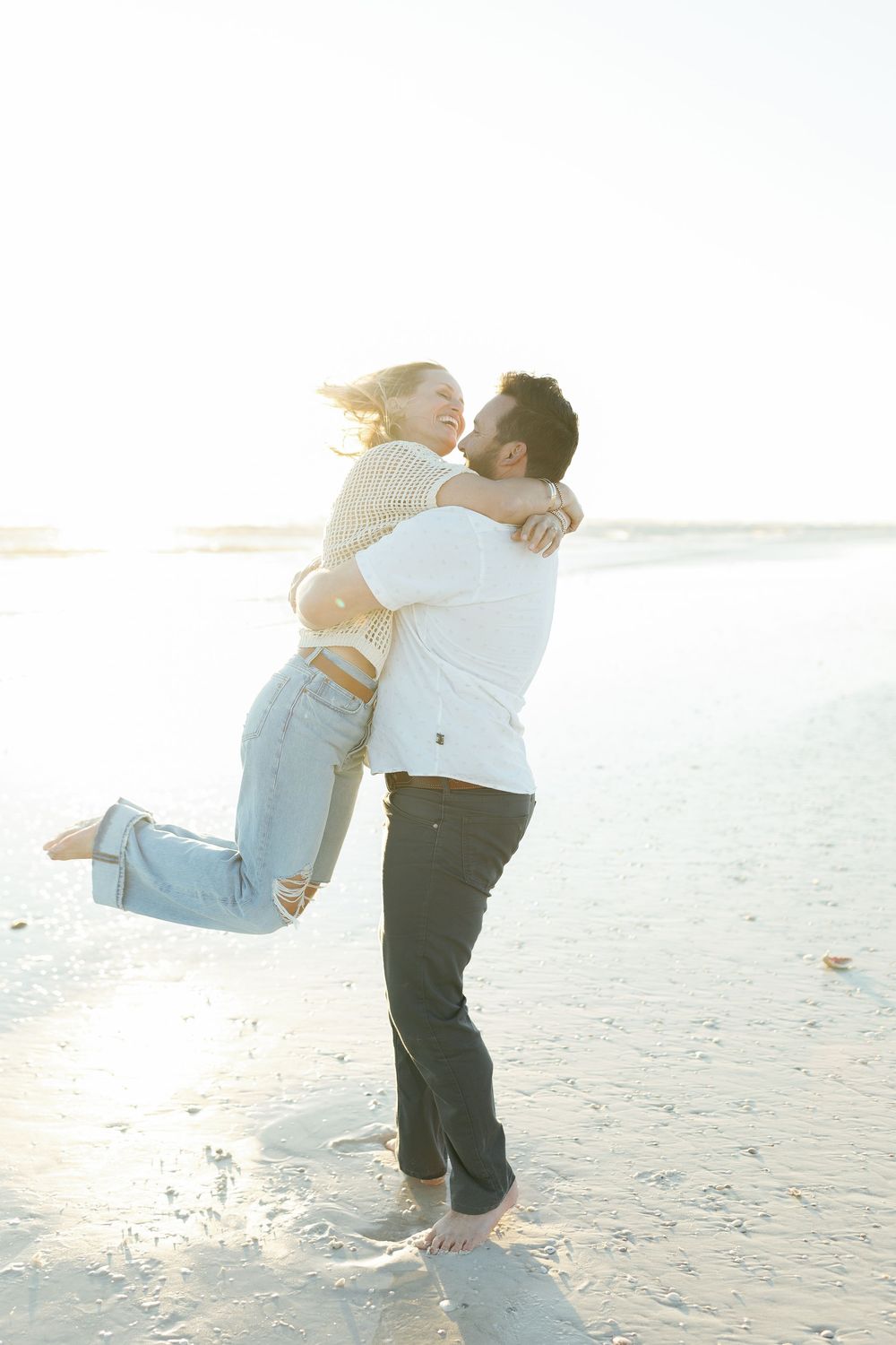 He lifts her off the ground as they celebrate their engagement