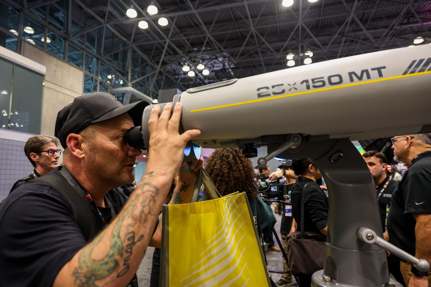A person examines a model aircraft display at a busy aviation industry trade show.