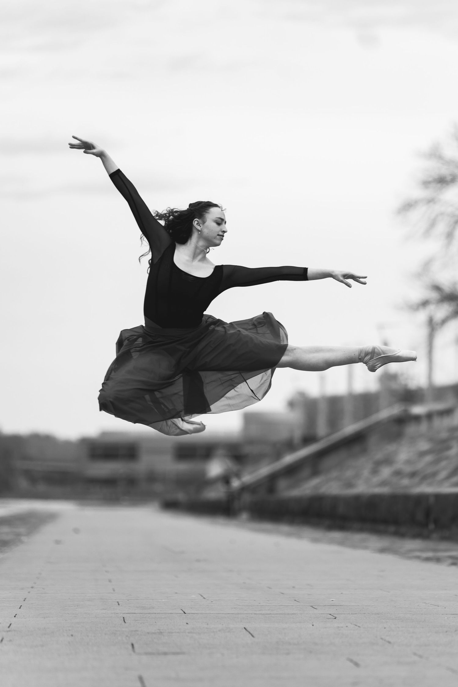 Elegant dancer in skirt performing a jump near the confluence of Pittsburgh's rivers during sunset pittsburgh dance photography