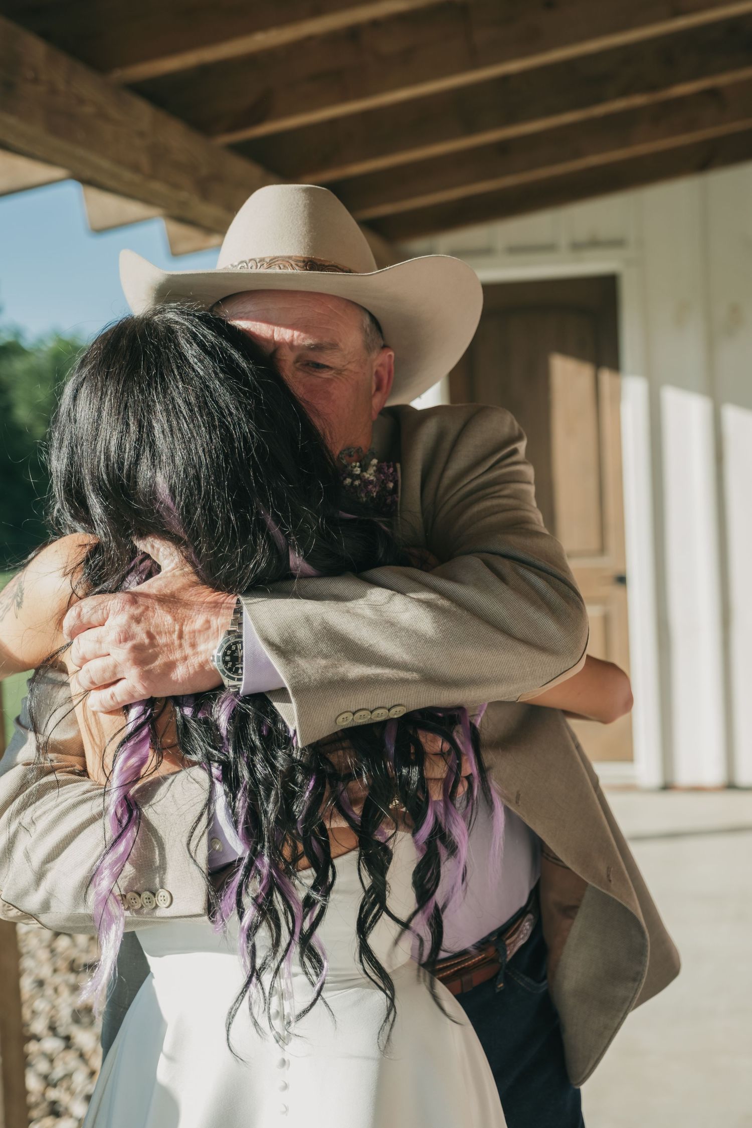 Sequence of five similar photos showing an emotional embrace between two people wearing cowboy hats at an outdoor venue.