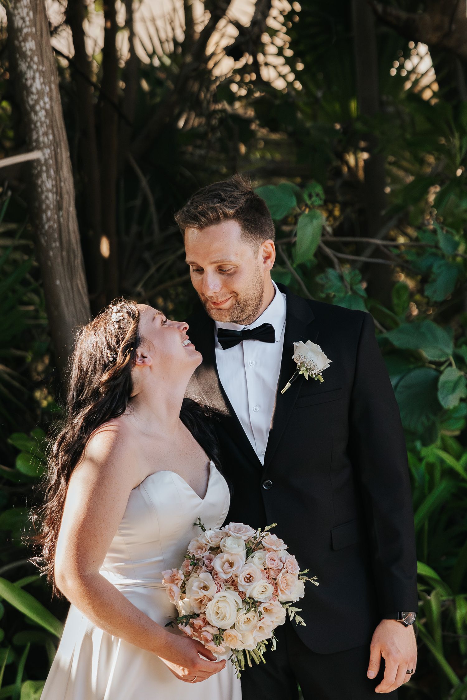 Cancun Mexico
A smiling couple shares a tender moment in a garden setting at their wedding, with the bride holding a pink and white bouquet.