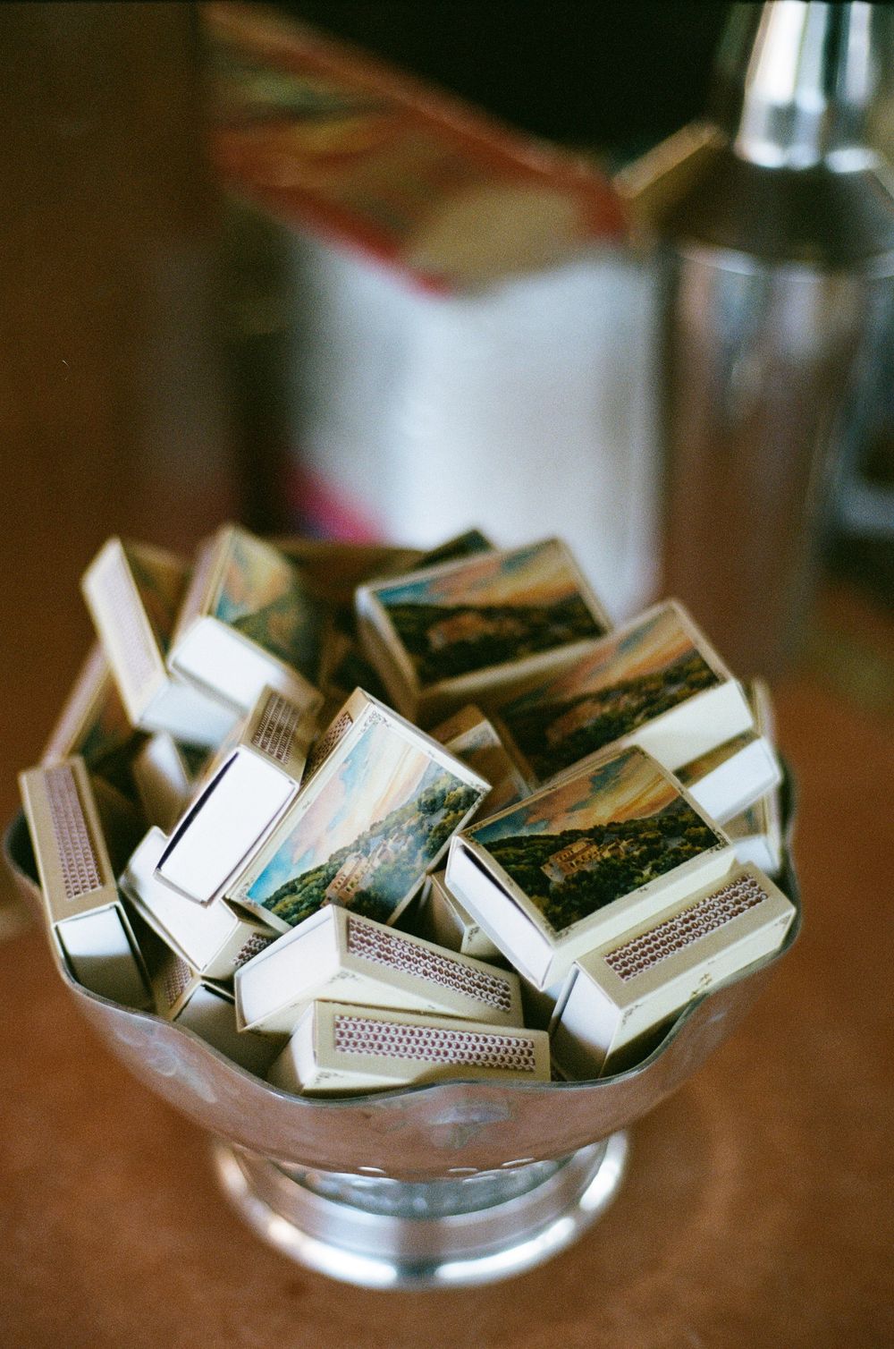 Collection of vintage matchboxes displayed in a glass bowl at an event.