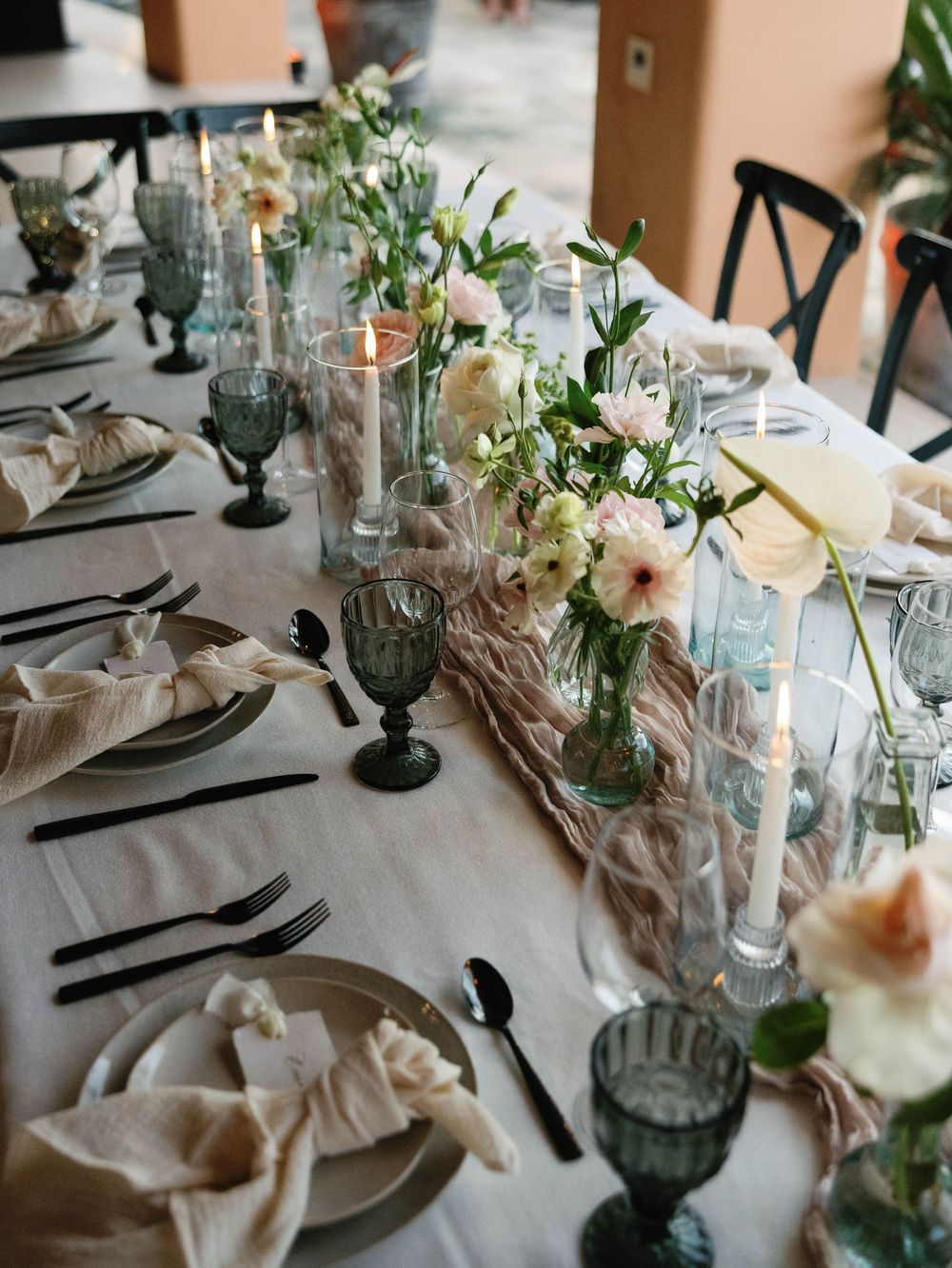 Elegant wedding table setting with gray glassware and white floral centerpieces.