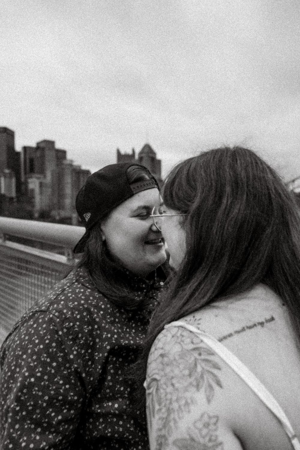 A candid black and white moment captured on a rooftop with the New York City skyline in the background.