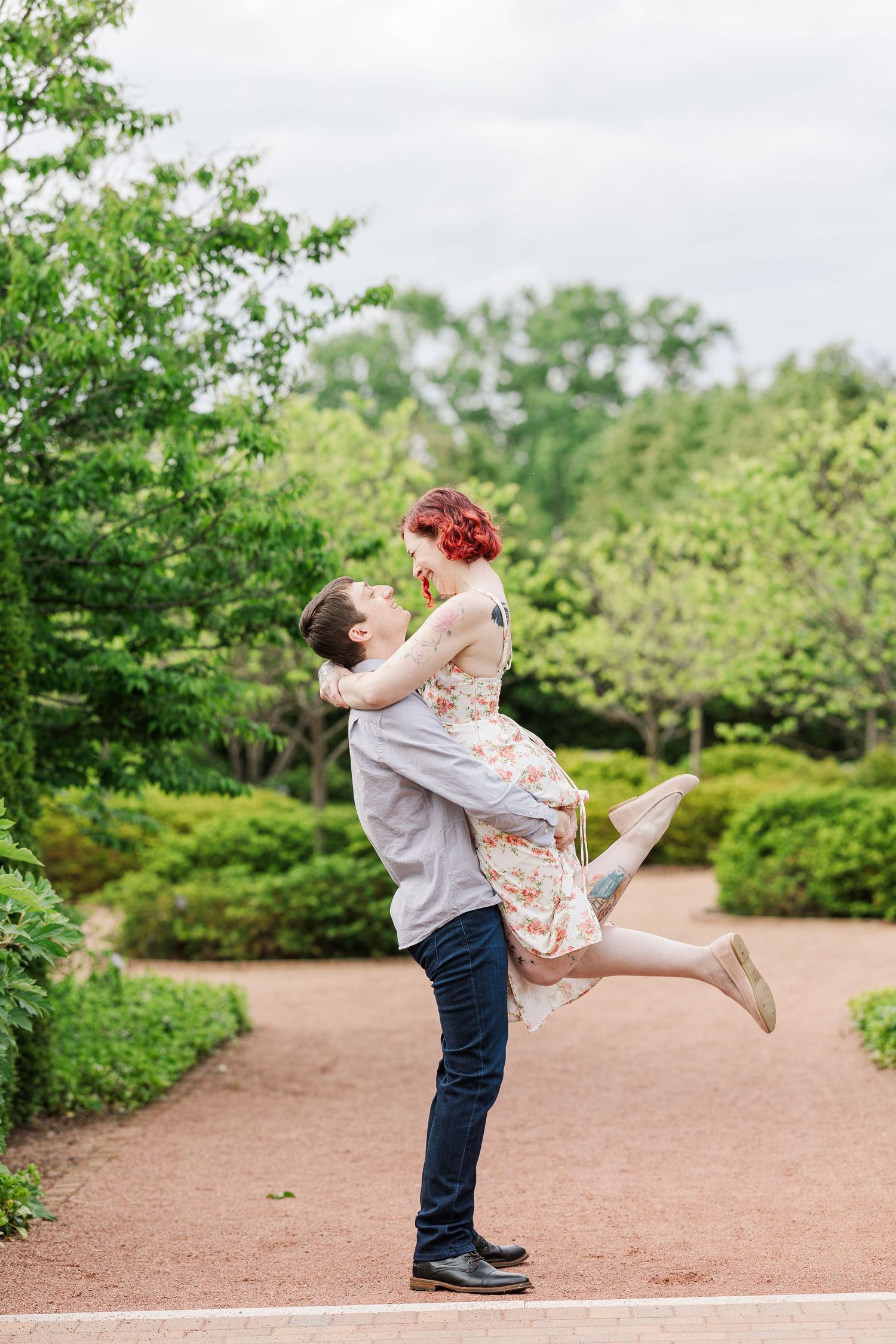A romantic moment captured in a lush garden setting with lifted embrace on a brick pathway at Cantigny Park