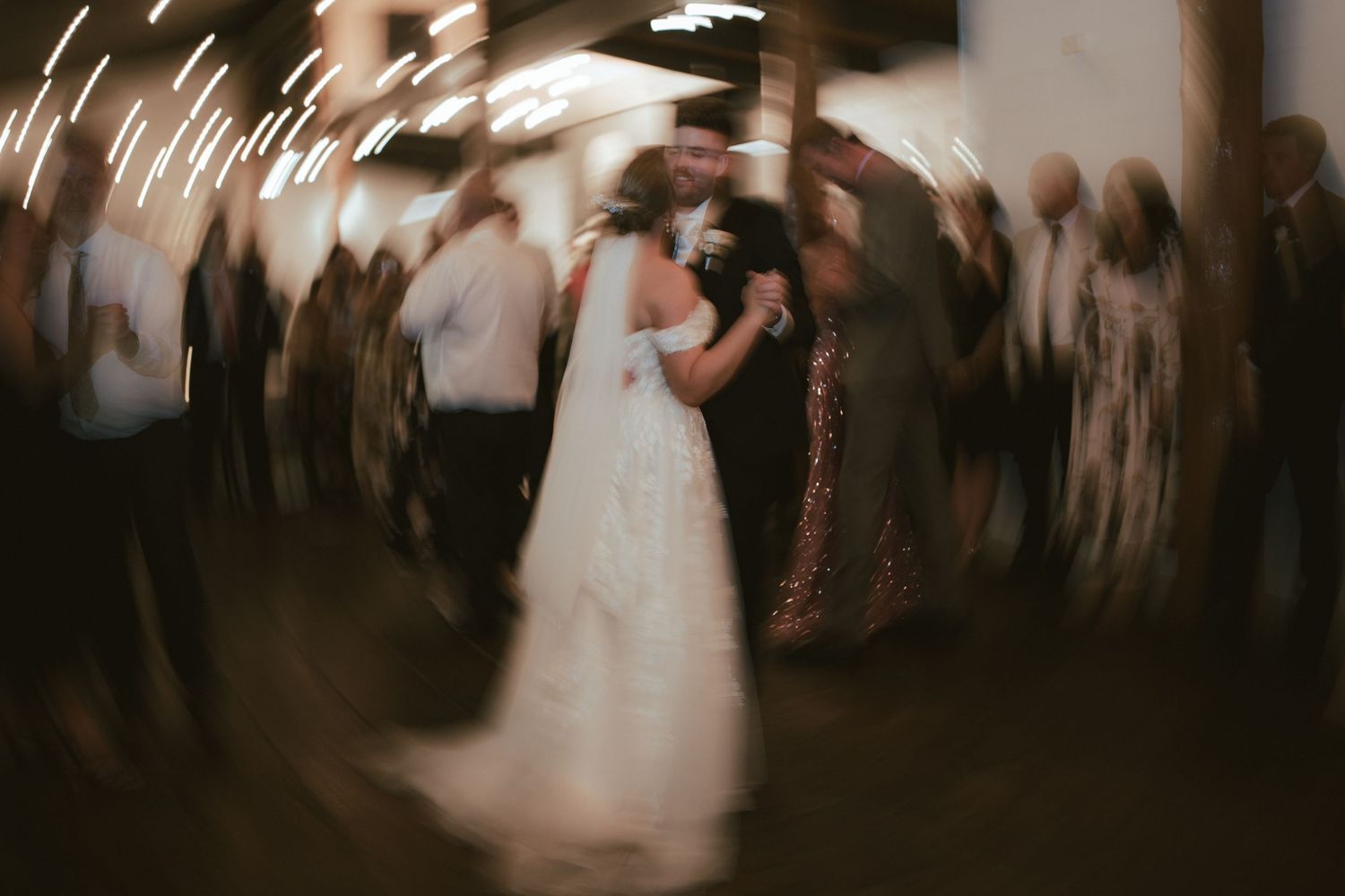 Artistic motion blur capture of wedding couple dancing at reception.