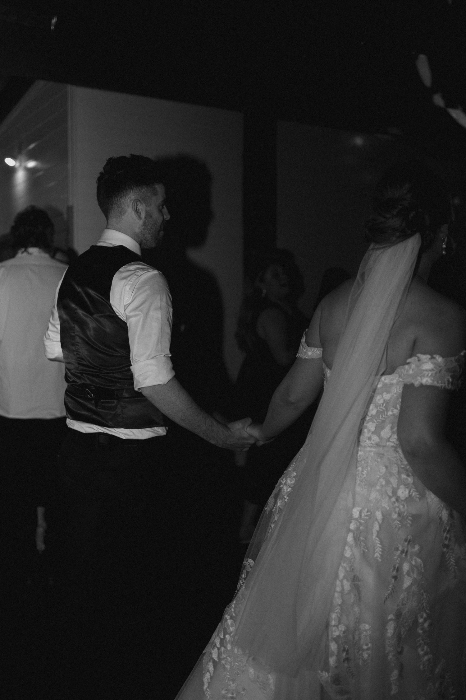 Black and white photo of couple dancing at wedding reception.