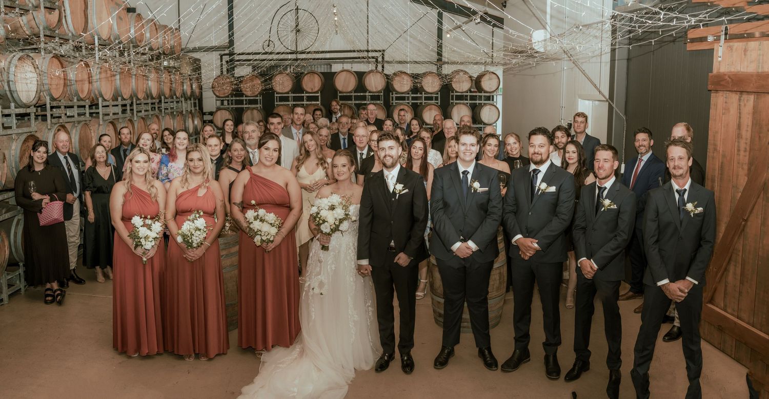 Wedding party lined up with bridesmaids in burgundy dresses and groomsmen in black suits.