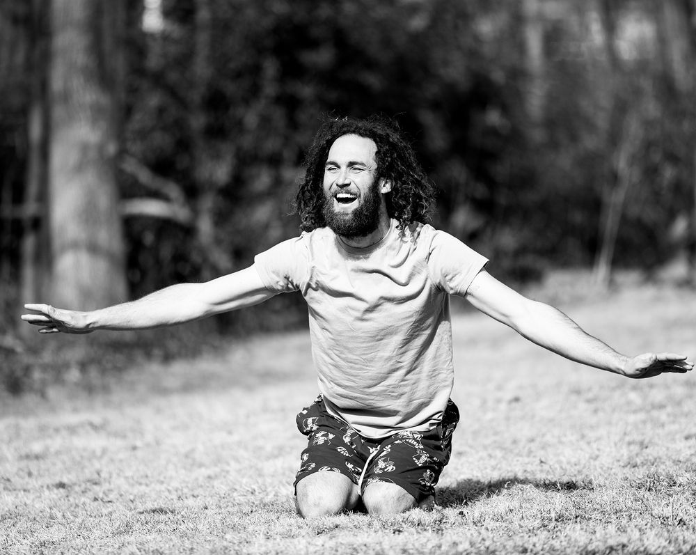 Black and white sequence showing a playful tumble across grass.