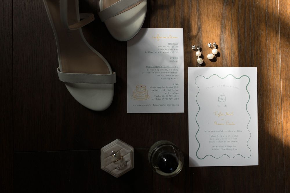 Minimalist wedding invitation suite with white cards and rings in natural light.