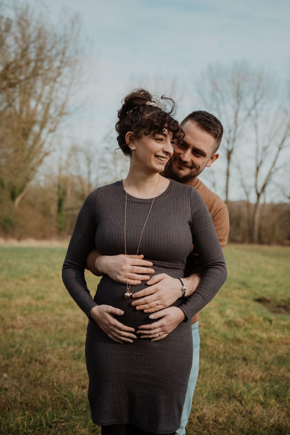 A loving embrace in an autumn field as a couple shares an intimate moment in nature.