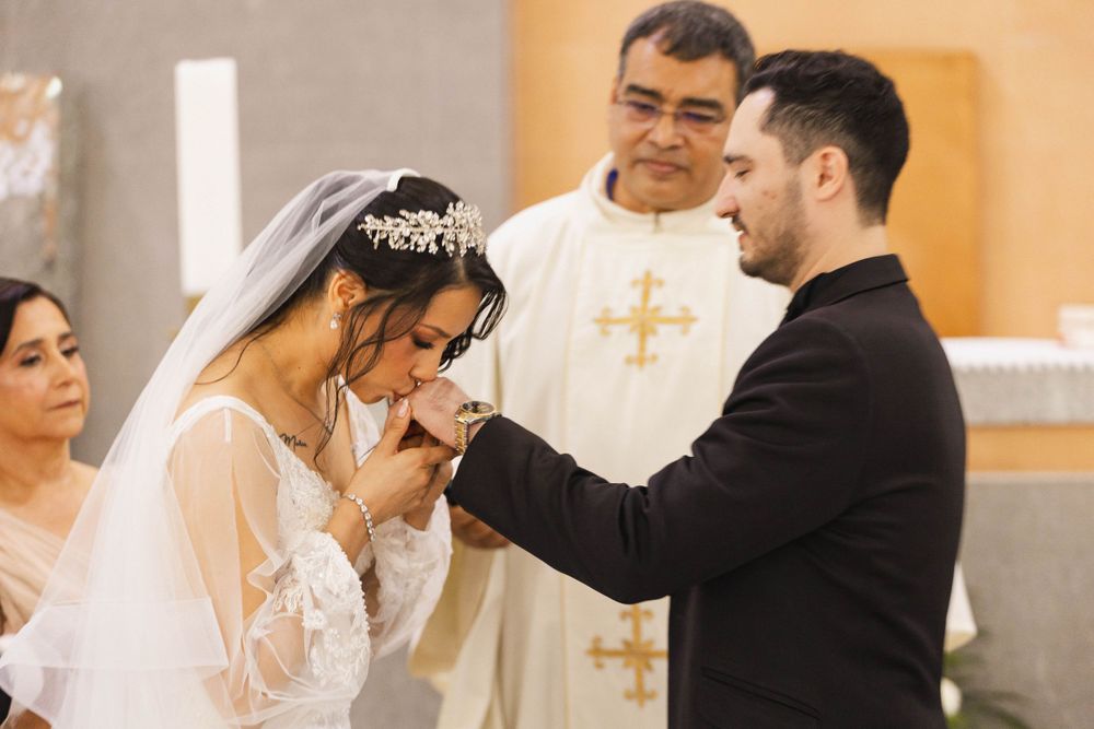 A tender moment during a Catholic wedding ceremony as the couple exchanges vows before the priest.