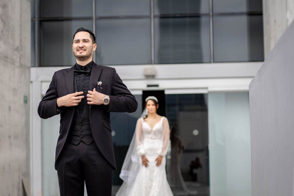 First look wedding moment captured between couple outside modern building.