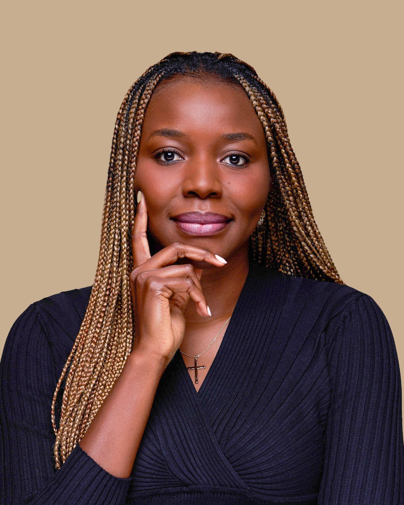 Professional portrait with long braided hair and navy top against neutral background.