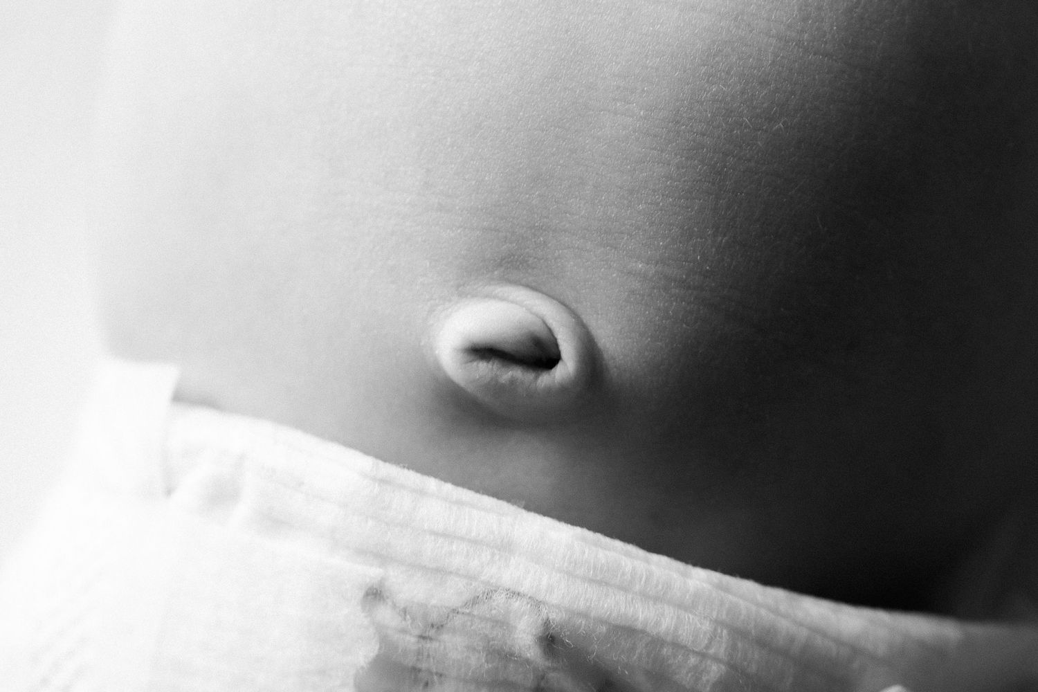 Close up black and white macro photograph of a nose against a soft blurred background.
