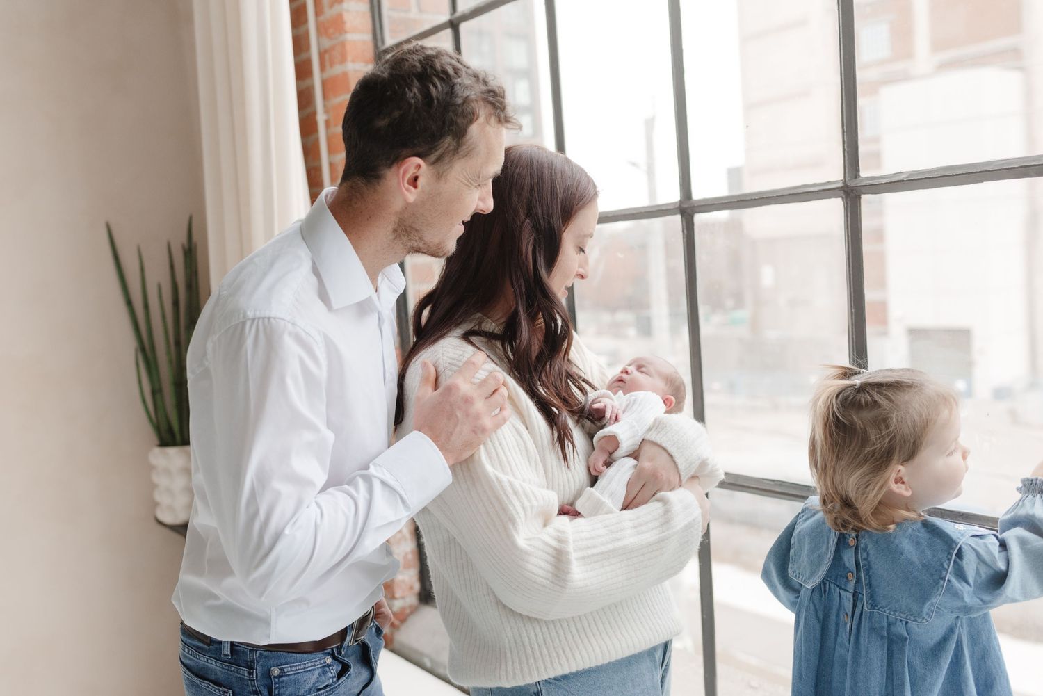 Family looking out the window at a Toronto Family Photoshoot in studio by Jess GC