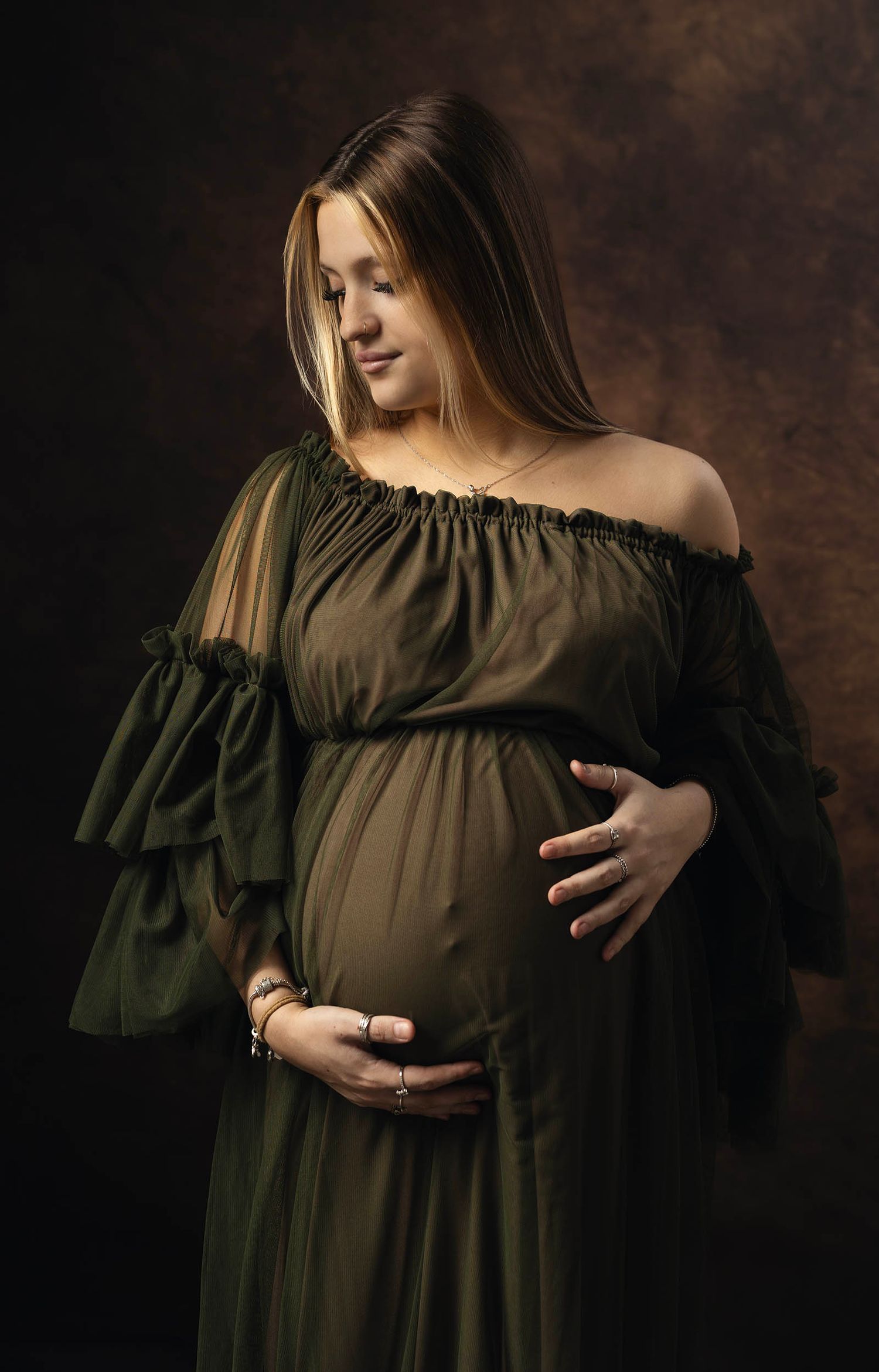 Maternity portrait showing woman in olive green dress, tiny moments photography maternity photo shoot in Gosport, Hampshire photo studio