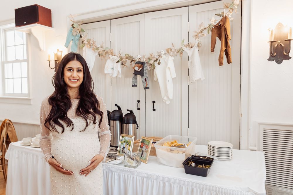 Baby shower celebration setup with white garland and decorative elements against closet doors.