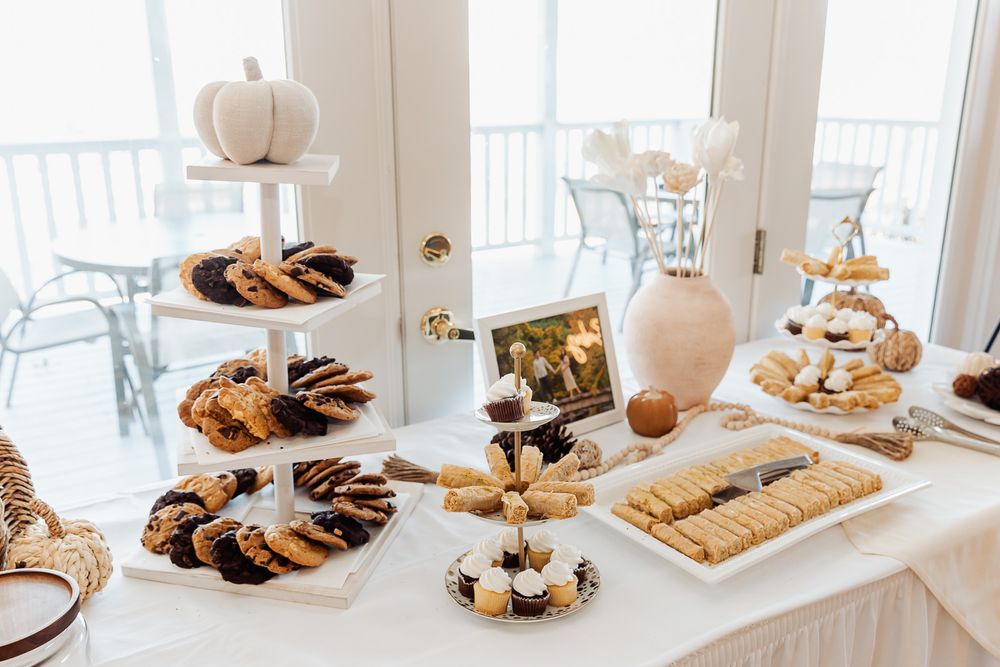 Elegant dessert table with tiered serving stands displaying cookies and treats at a festive gathering.