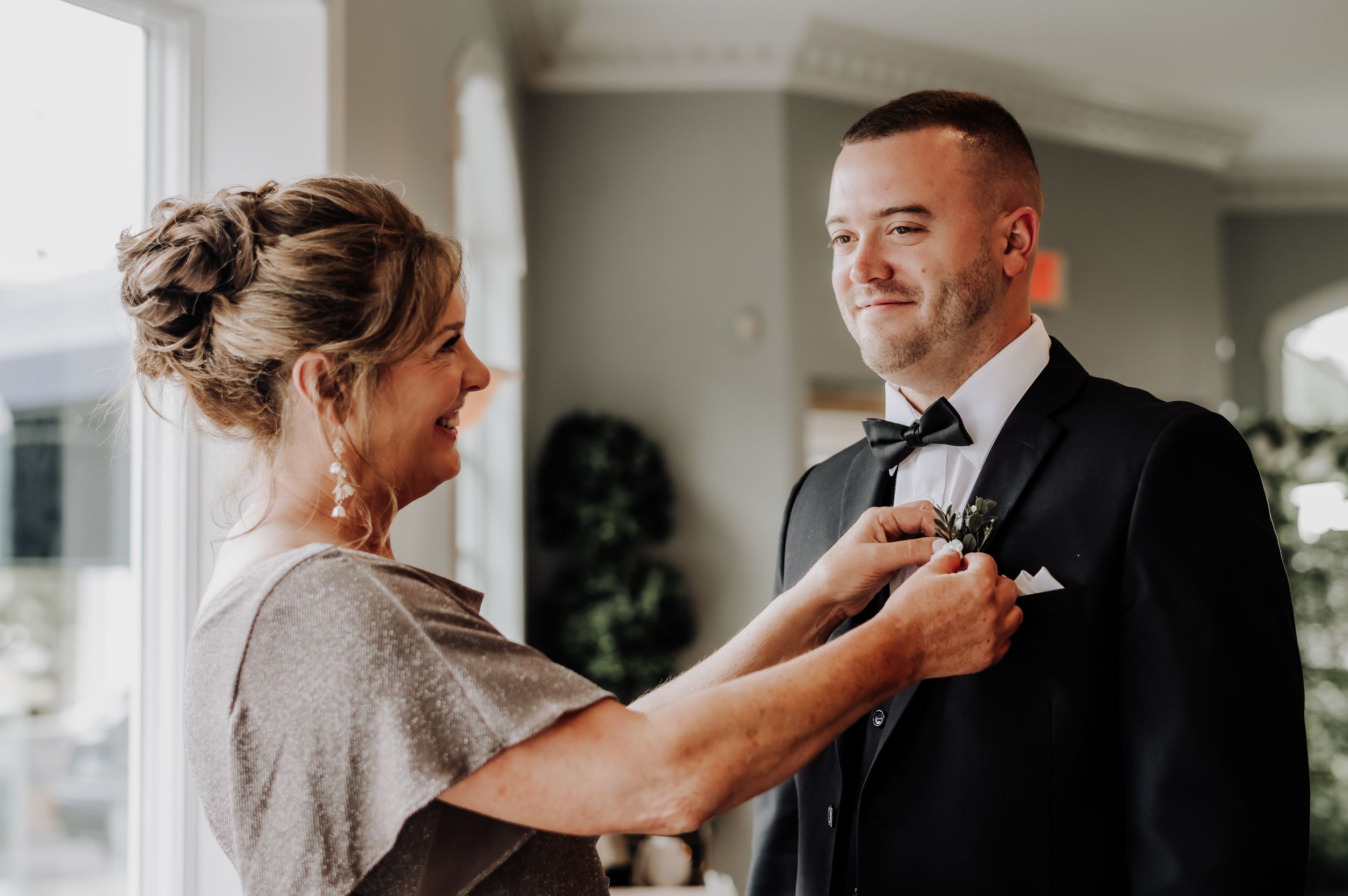 Getting ready moment as formal attire is adjusted before ceremony. Candlewood Inn, CT.