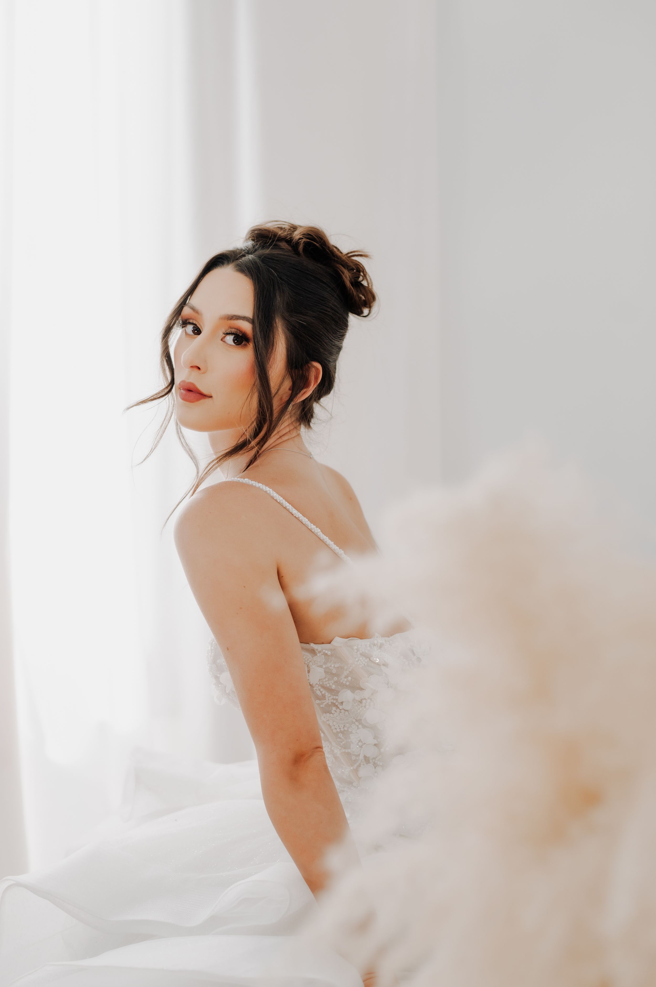 Sophisticated bridal portrait in white dress with elegant updo hairstyle.
