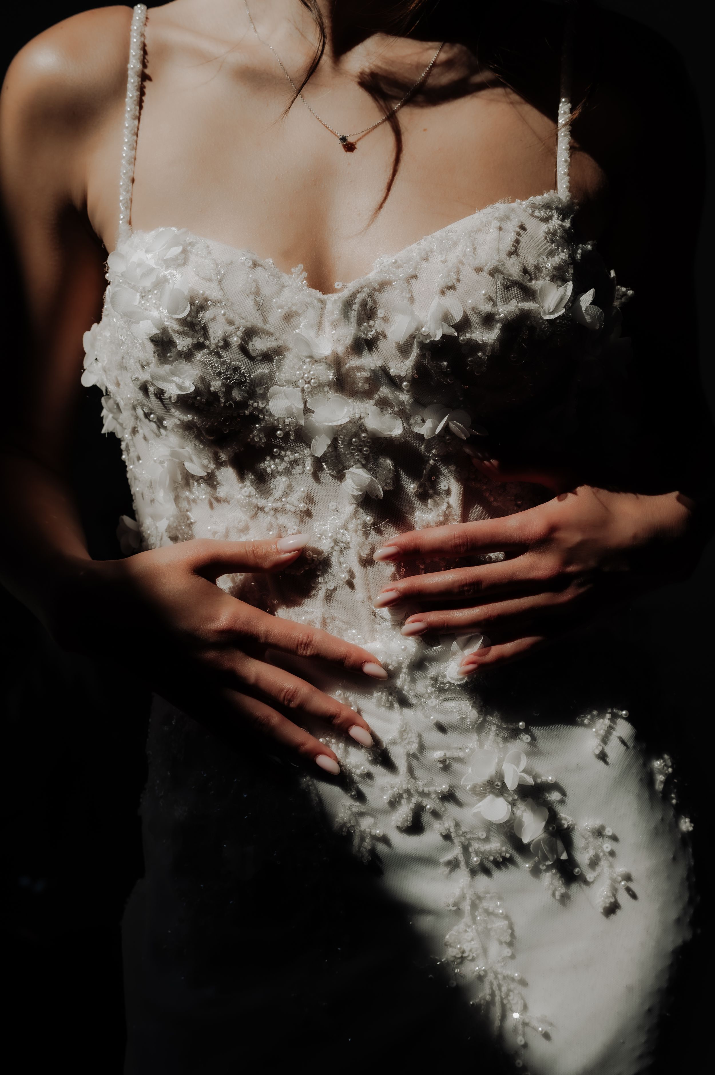 Close-up of textured white wedding dress bodice with intricate lace details.
