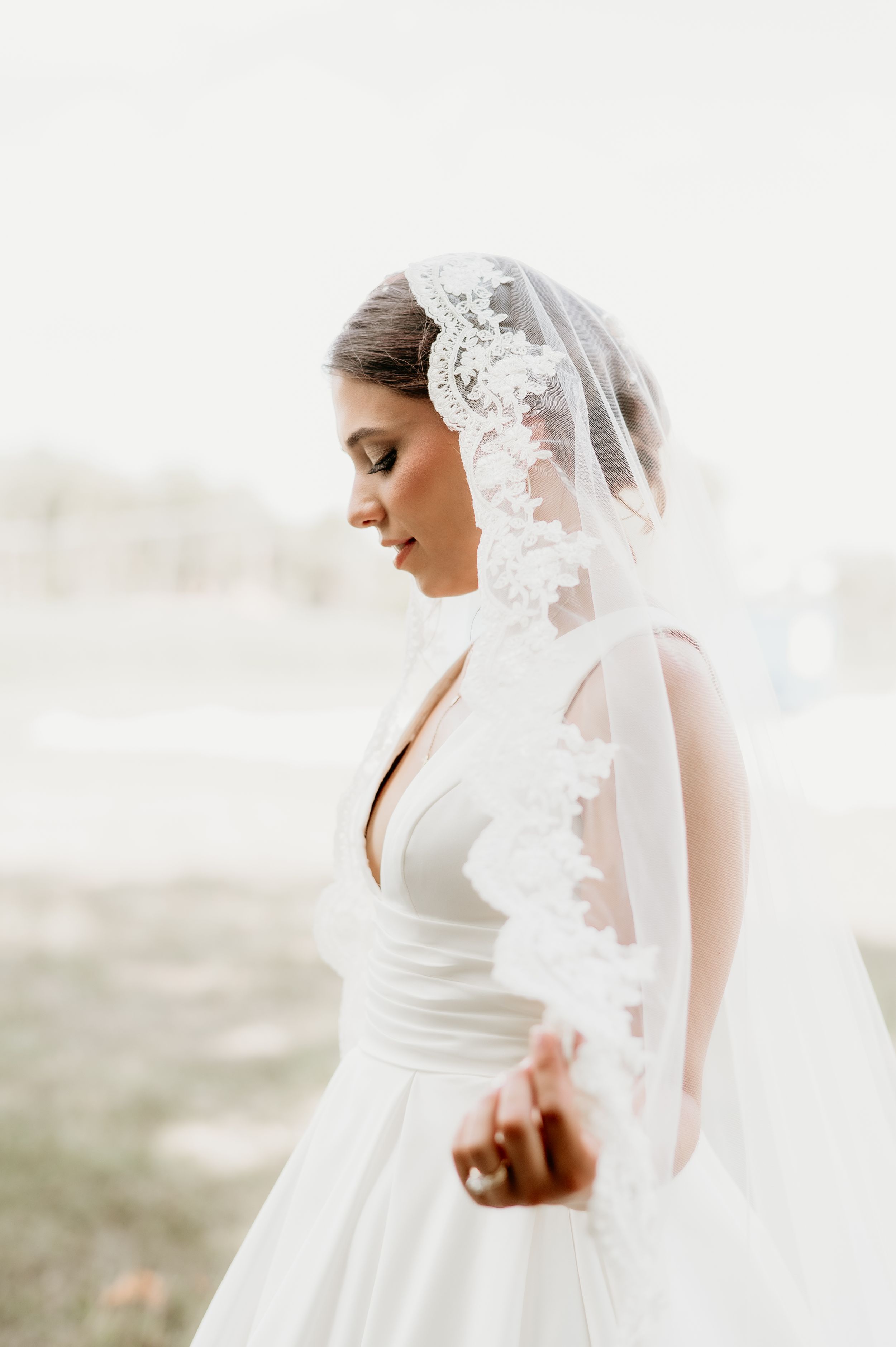 Elegant lace-trimmed wedding veil cascading down white bridal gown.