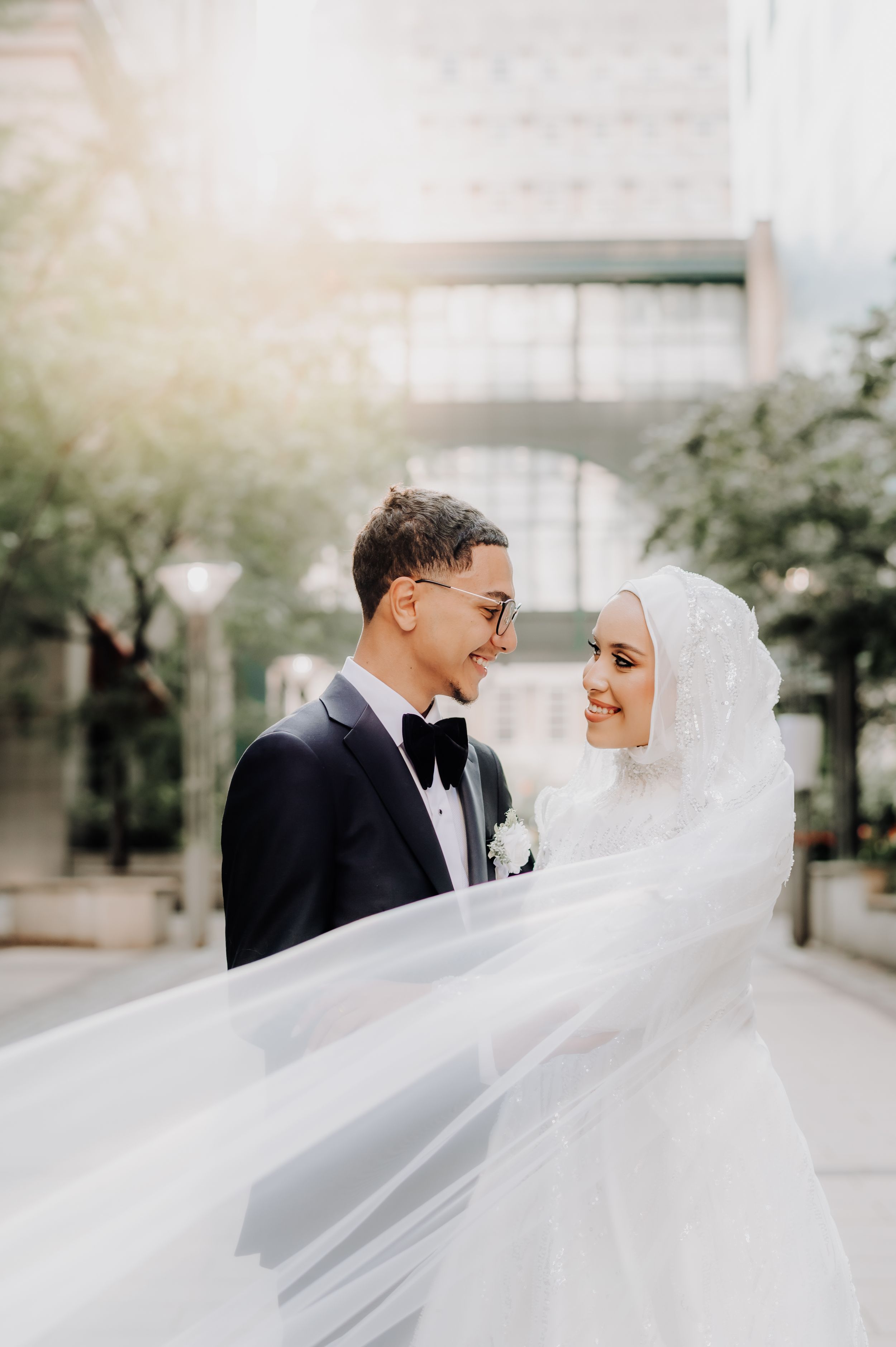 Romantic outdoor portrait of Muslim newlyweds with flowing veil in urban setting. New York City,