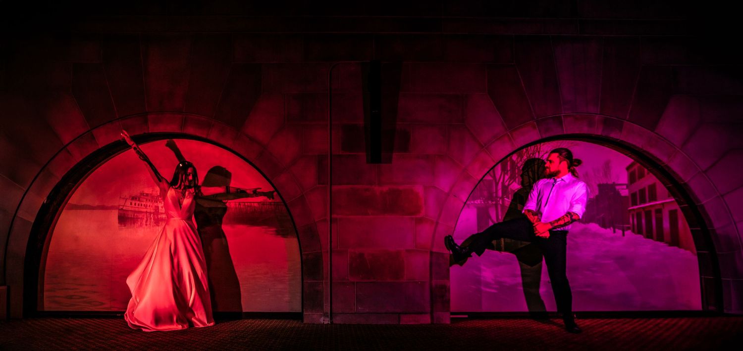 Two dramatic dance silhouettes in red-lit archways create a theatrical performance scene.