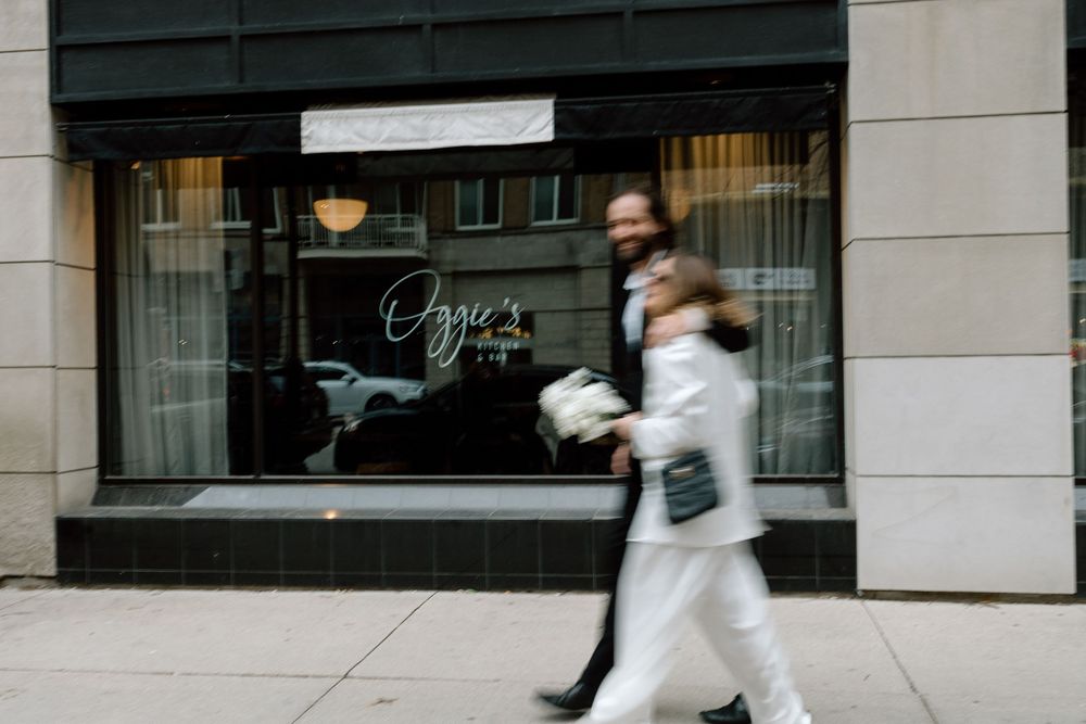 Blurred motion of people walking past a storefront window with 'Agnes' signage on a city street.