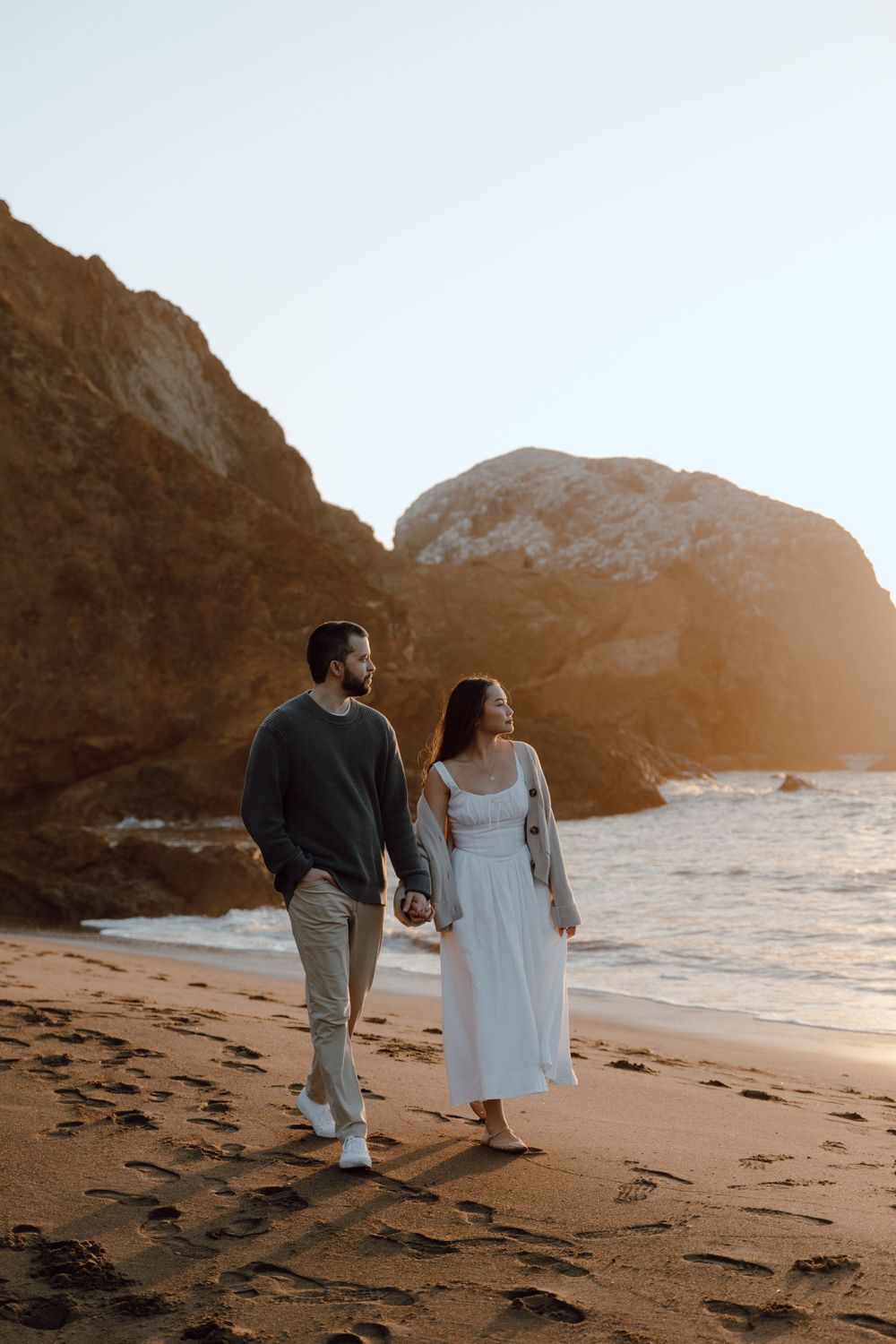 Sunset beach walk with dramatic coastal rock formations.