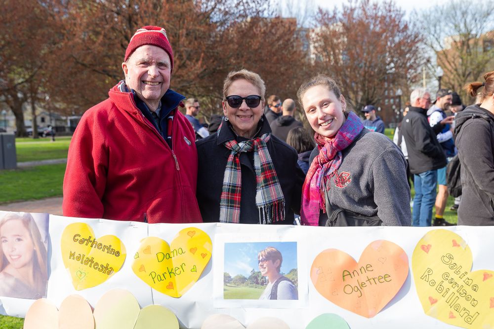 Participants gather near a display of colorful heart-shaped signs at an outdoor event.