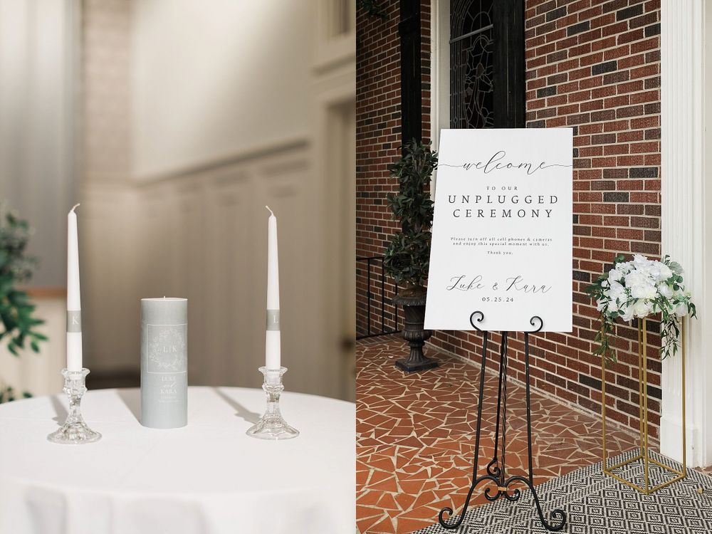 Elegant wedding decor featuring white candles and a welcome sign against a brick wall.