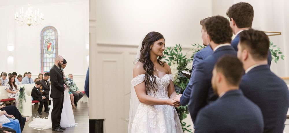 Wedding ceremony in progress inside bright white chapel with decorative floral arrangements.
