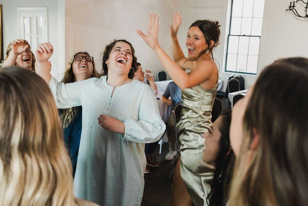Joyful celebration with guests dancing and laughing at a wedding reception.
