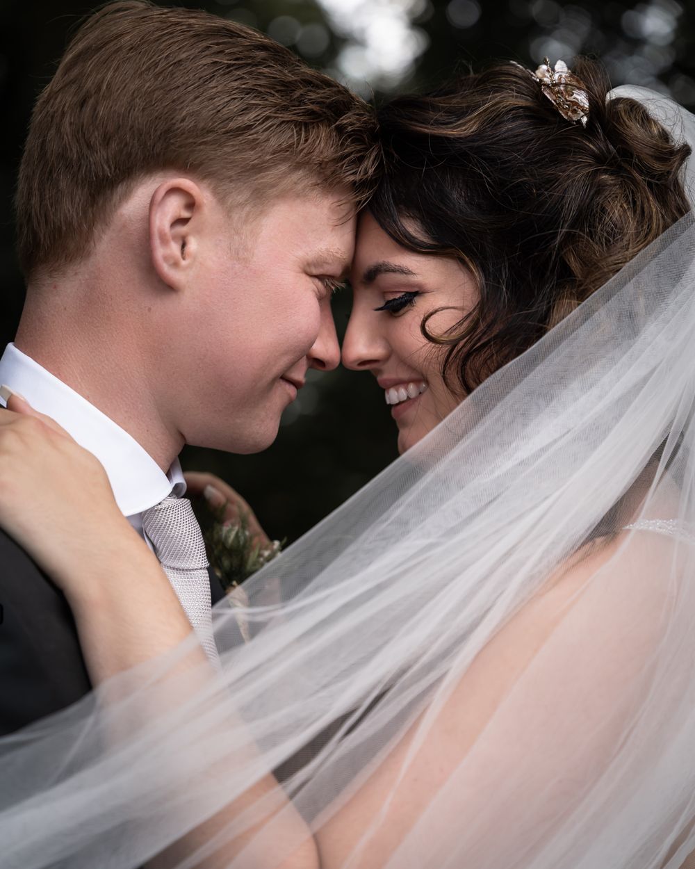 Bruiloftsfoto van een bruidspaar tijdens hun huwelijksdag bij trouwlocatie kasteel Wijenburg echteld bruidspaar houdt gezichten tegen elkaar