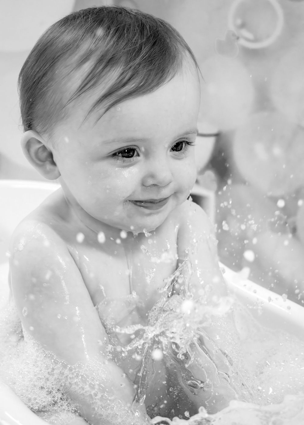 Black and white portrait capturing water splashes and joyful expressions.